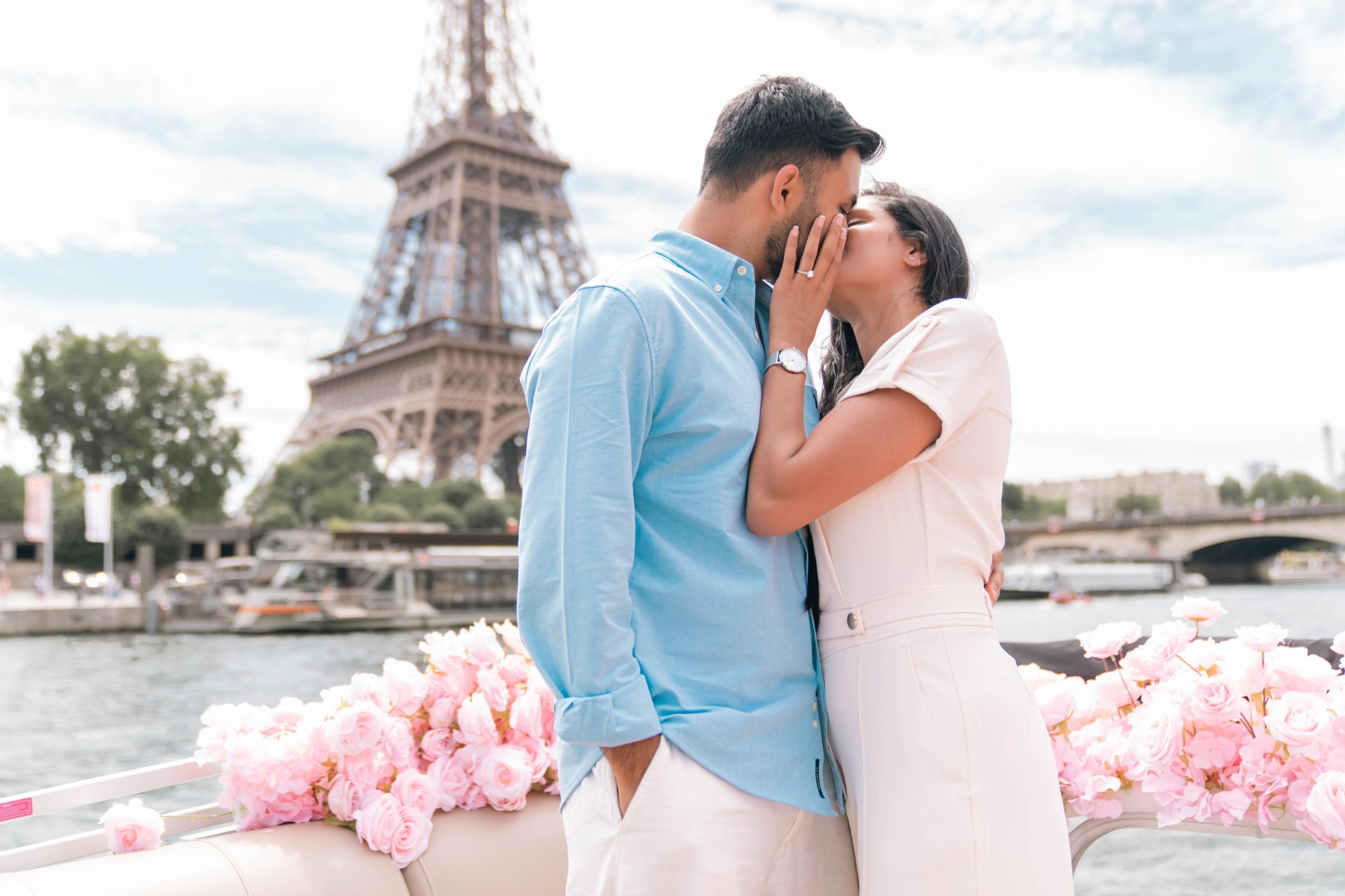 Couple debout sur un bateau devant la Tour Eiffel sur un bateau